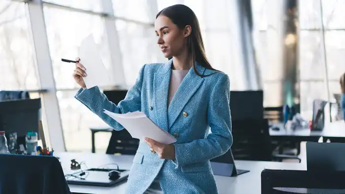 Directora de una empresa trasnacional exponiendo una estrategia de negocios ante equipos de trabajo 